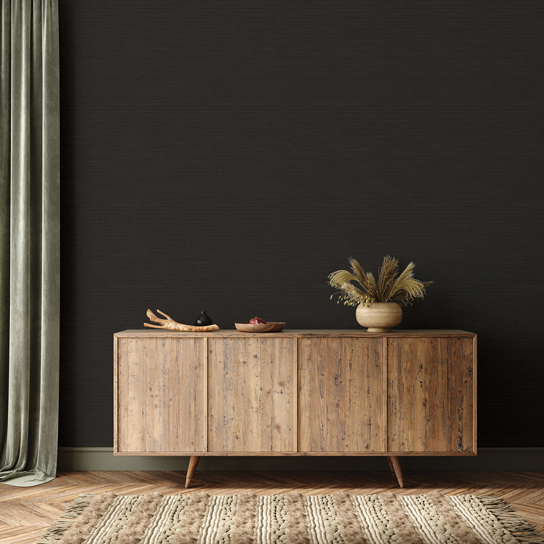 Faux Horizontal Grasscloth Removable Wallpaper - A wood sideboard and a rug in a room featuring Faux Horizontal Grasscloth Peel And Stick Wallpaper in textured black raven | Tempaper#color_textured-black-raven