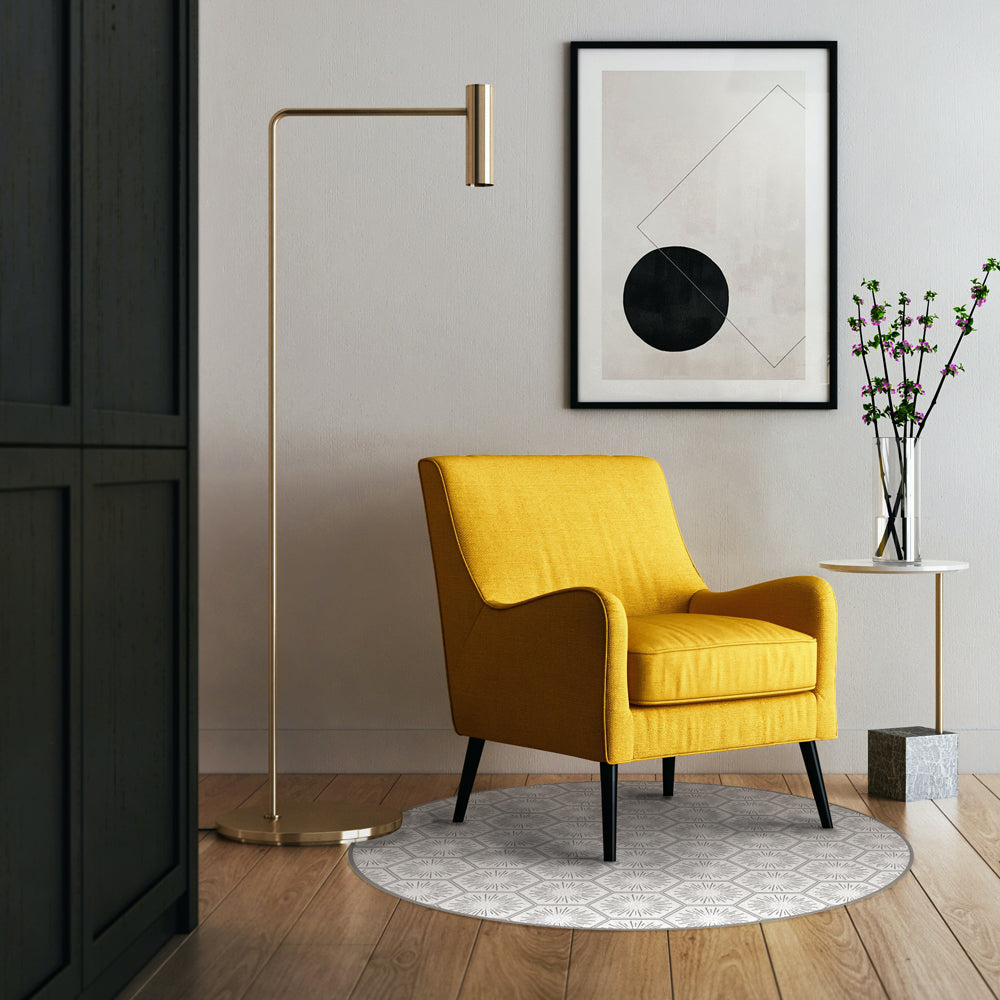 Tempaper's Hello Sunshine Vinyl rug shown in grey in underneath a yellow chair.
