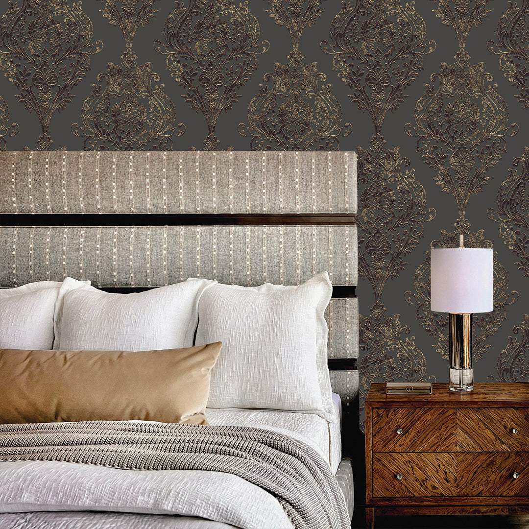 Estate Damask Non-Pasted Wallpaper - A bedroom and nightstand in front of Estate Damask Unpasted Wallpaper in charcoal damask | Tempaper#color_charcoal-damask