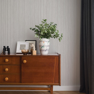 Faux Grasscloth Removable Wallpaper - A wood sideboard with a vase and plant in a room featuring Faux Grasscloth Peel And Stick Wallpaper in textured sterling silver | Tempaper#color_textured-sterling-silver