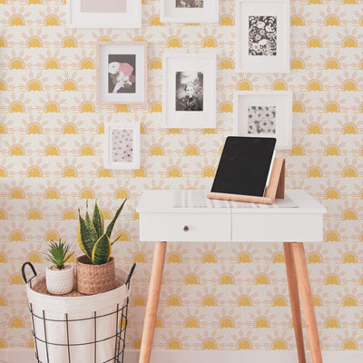 Tempaper's Sun Peel And Stick Wallpaper with a white desk and framed pictures.