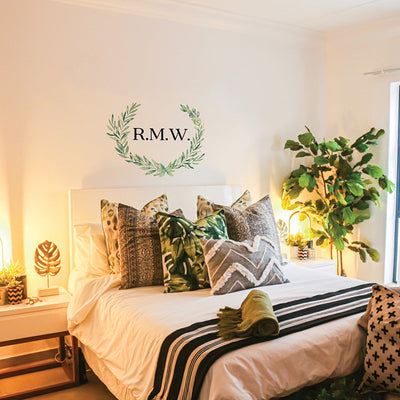 Tempaper's Custom Initials Wall Decal Set in black with "R.M.W." as an example shown above a bed.#color_black