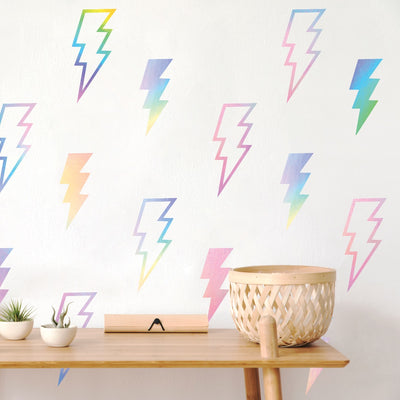 Tempaper's holographic Lightning Bolts wall decals on a wall behind a wood table.