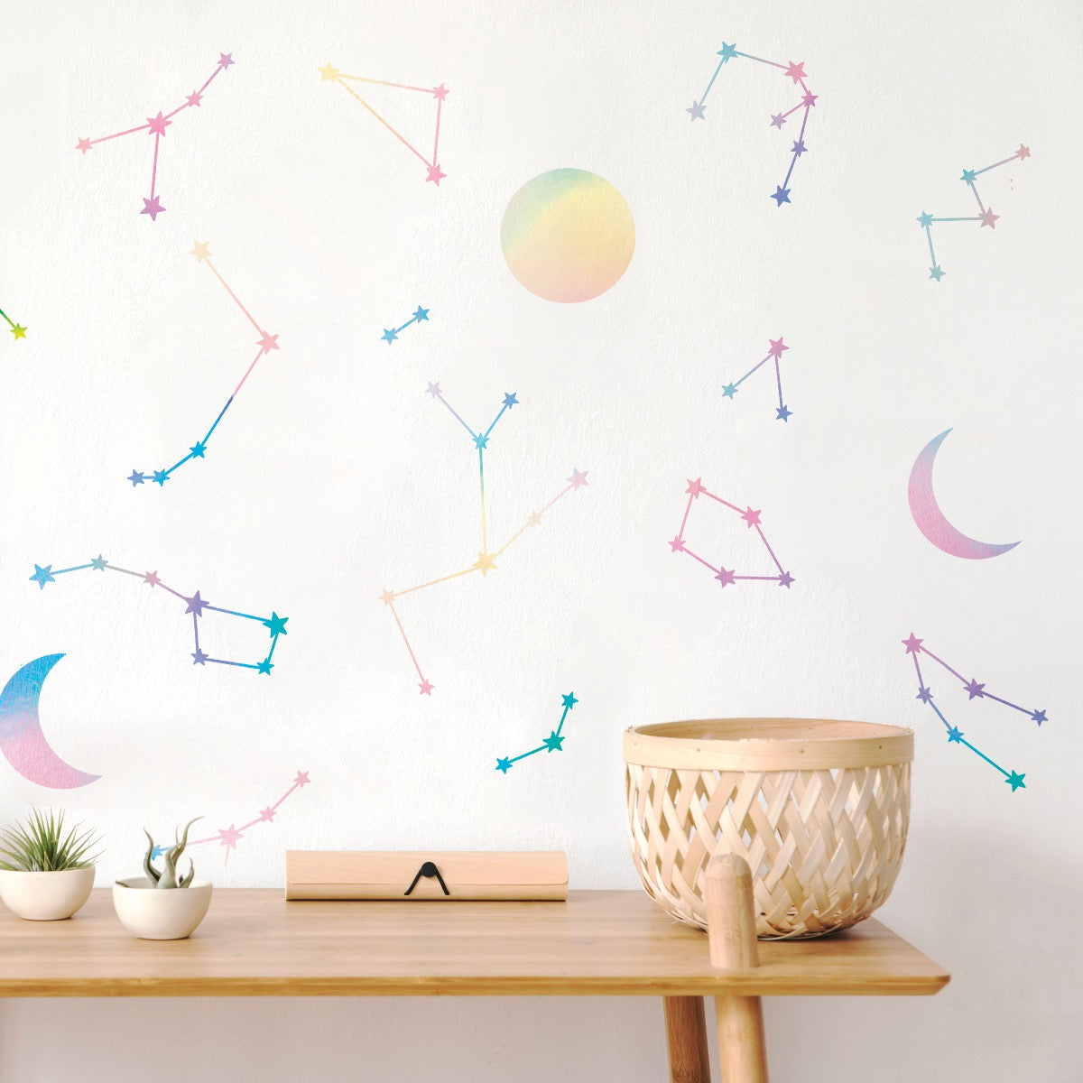 A side table in front of a wall decorated with holographic Constellations & Moons wall decals from Tempaper.