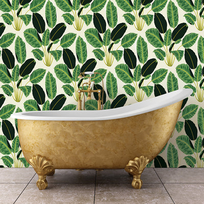 Tempaper's emerald Hojas Cubanas removable wallpaper behind a gold claw foot tub in a bathroom.