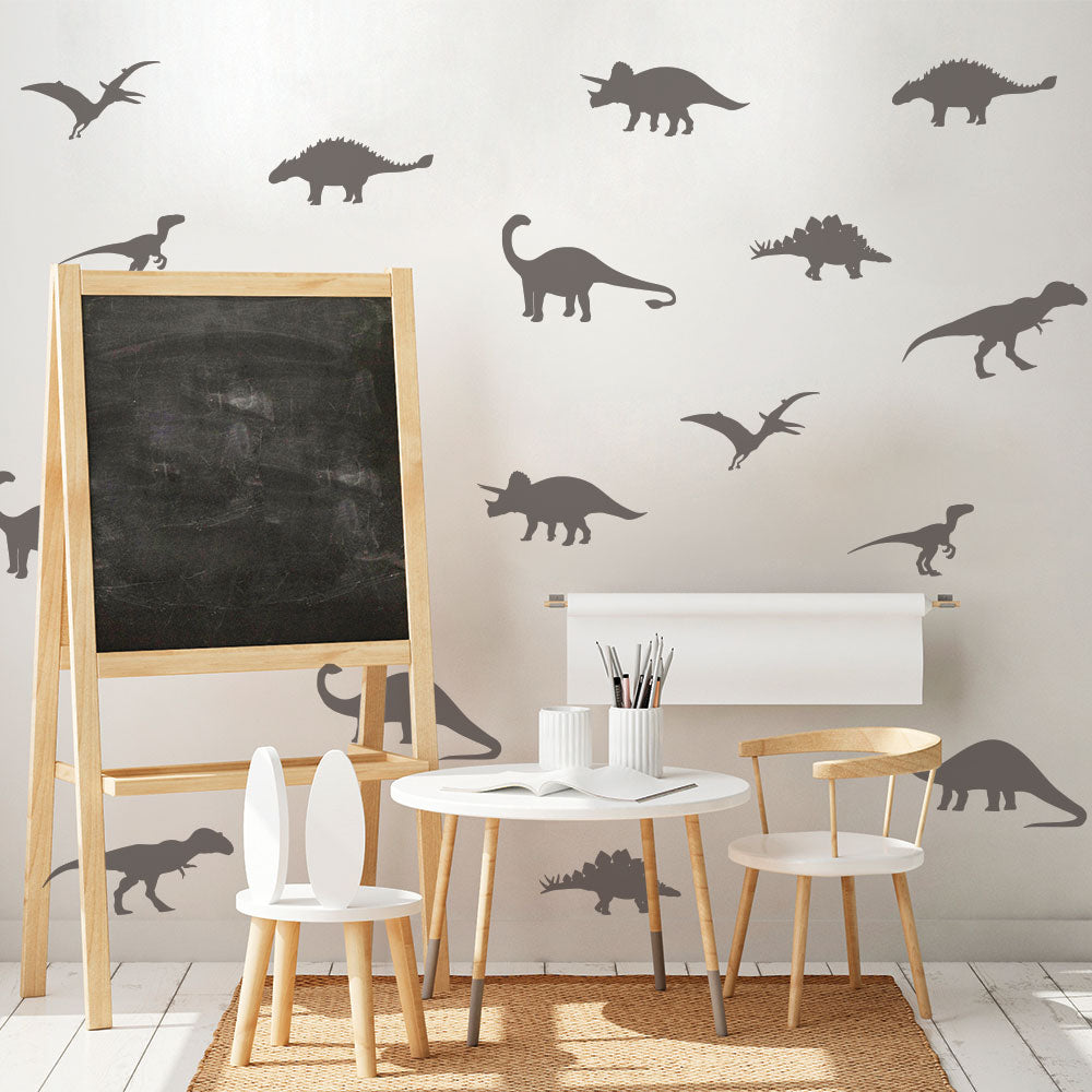 Tempaper's Dinosaur Wall Decals shown behind a table, chairs, and a chalkboard.