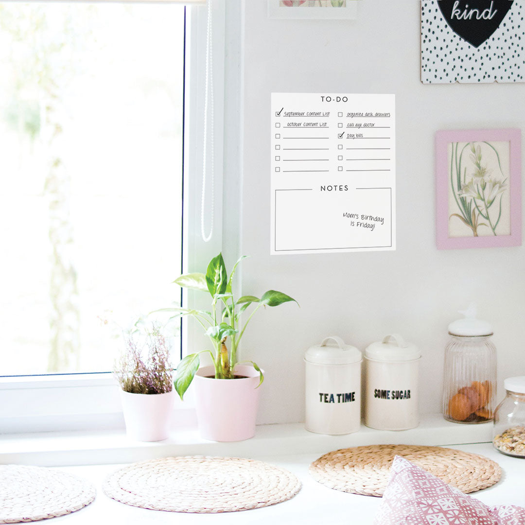 Tempaper's Dry Erase To-Do List Wall Decal shown next to a window and above a plant.