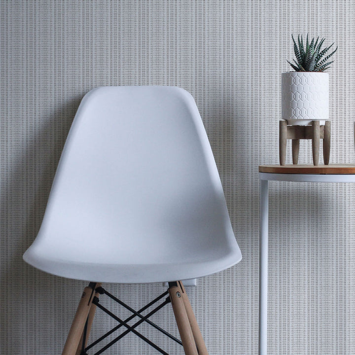 Batik Stripe Removable Wallpaper - A white chair and plant in a room featuring Batik Stripe Peel And Stick Wallpaper in french grey | Tempaper#color_french-grey