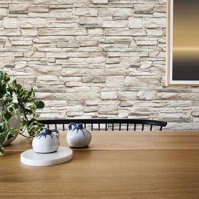 Light Stone Removable Wallpaper - A wood table with a plant in front of a wall featuring Tempaper's Light Stone Peel And Stick Wallpaper | Tempaper