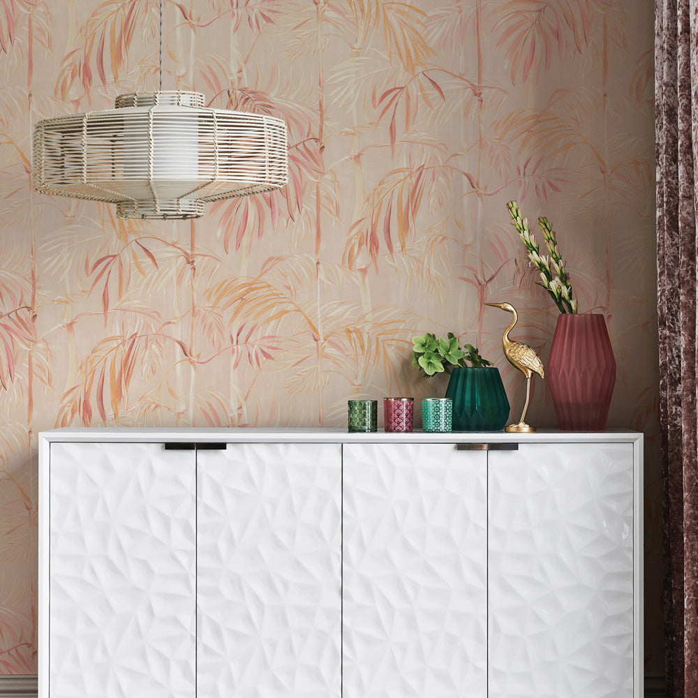 Bamboo Gardens Non-Pasted Wallpaper - A white dresser with plants and candles on top in front of Bamboo Gardens Unpasted Wallpaper in coral | Tempaper#color_coral