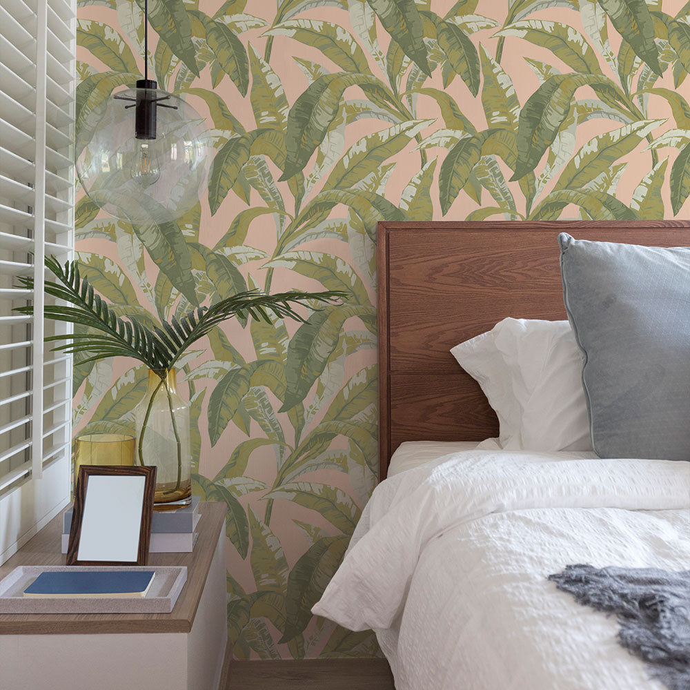 Banana leaf peel and stick wallpaper in a bedroom displayed behind a bed.