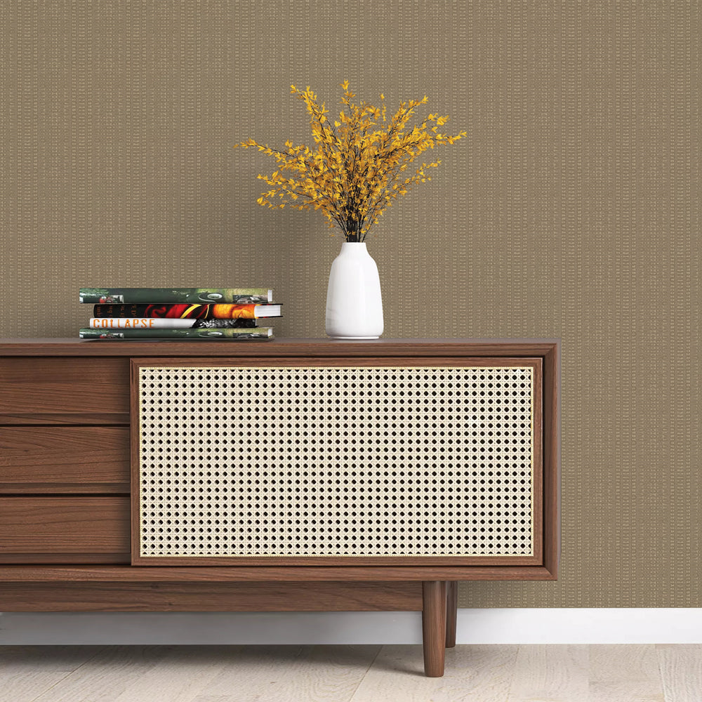 Batik Stripe Removable Wallpaper - A wood sideboard with books and a white vase on top in a room featuring Batik Stripe Peel And Stick Wallpaper in macadamia | Tempaper#color_macadamia