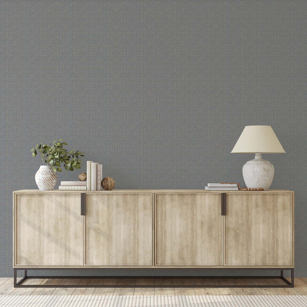 Batik Stripe Removable Wallpaper - A wood sideboard with a vase and lamp on top in front of a wall featuring Batik Stripe Peel And Stick Wallpaper in denim | Tempaper#color_denim