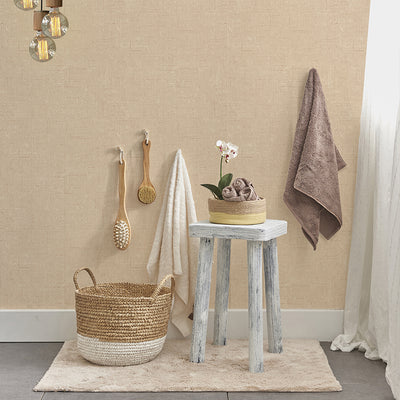 Burlap Removable Wallpaper - A woven basket and a grey wood stool in a bathroom featuring Burlap Peel And Stick Wallpaper in natural burlap | Tempaper#color_natural-burlap