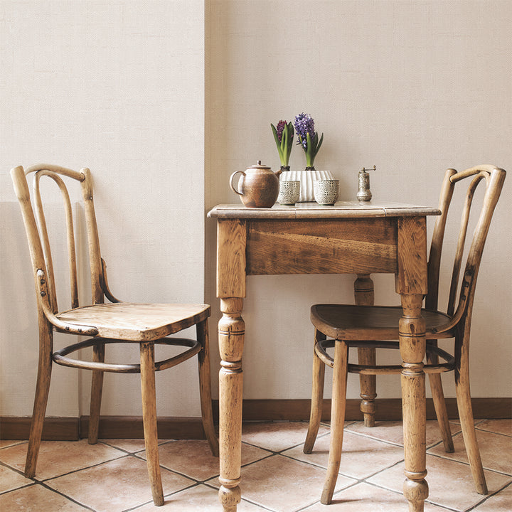 Burlap Removable Wallpaper - Two wood chairs and a wood table in a room featuring Burlap Peel And Stick Wallpaper in linen burlap | Tempaper#color_linen-burlap