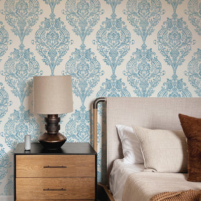 Estate Damask Non-Pasted Wallpaper - A bedroom and nightstand in front of Estate Damask Unpasted Wallpaper in coastal blue damask | Tempaper#color_coastal-blue-damask