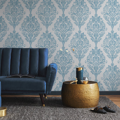 Estate Damask Non-Pasted Wallpaper - A blue couch and bronze end table in a room featuring Estate Damask Unpasted Wallpaper in coastal blue damask | Tempaper#color_coastal-blue-damask