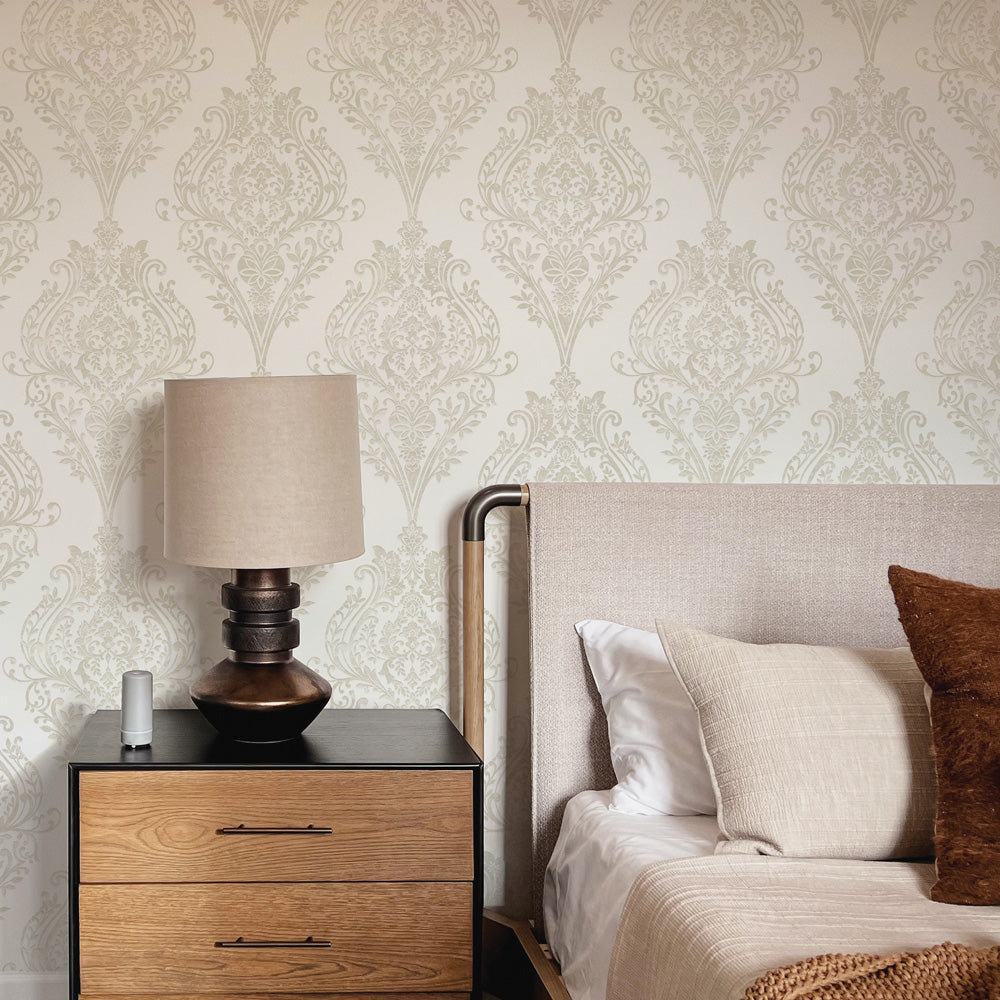 Estate Damask Non-Pasted Wallpaper - A bedroom and nightstand in front of Estate Damask Unpasted Wallpaper in champagne damask | Tempaper#color_champagne-damask