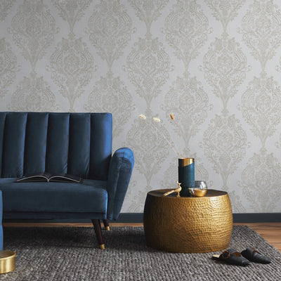 Estate Damask Non-Pasted Wallpaper - A blue couch and bronze end table in a room featuring Estate Damask Unpasted Wallpaper in champagne damask | Tempaper#color_champagne-damask