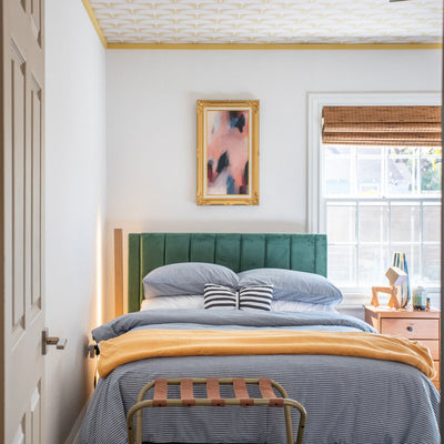 Feather Flock Removable Wallpaper - A bed with a green headboard and a wood nightstand in a bedroom with a ceiling featuring Tempaper's Feather Flock Peel And Stick Wallpaper in golden hour scallops#color_golden-hour-scallops