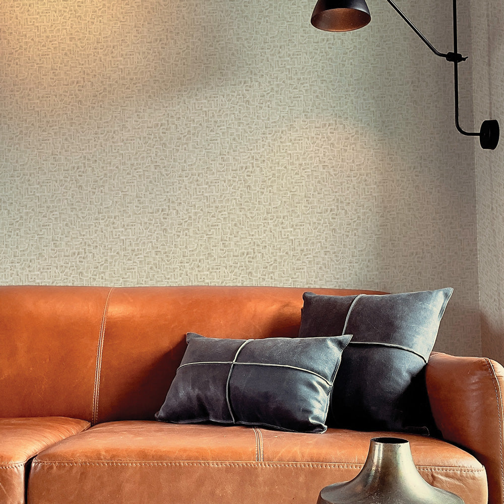 Glyph Geo Non-Pasted Wallpaper - A brown leather couch with black pillows in front of Glyph Geo Unpasted Wallpaper in fawn geo | Tempaper#color_fawn-geo