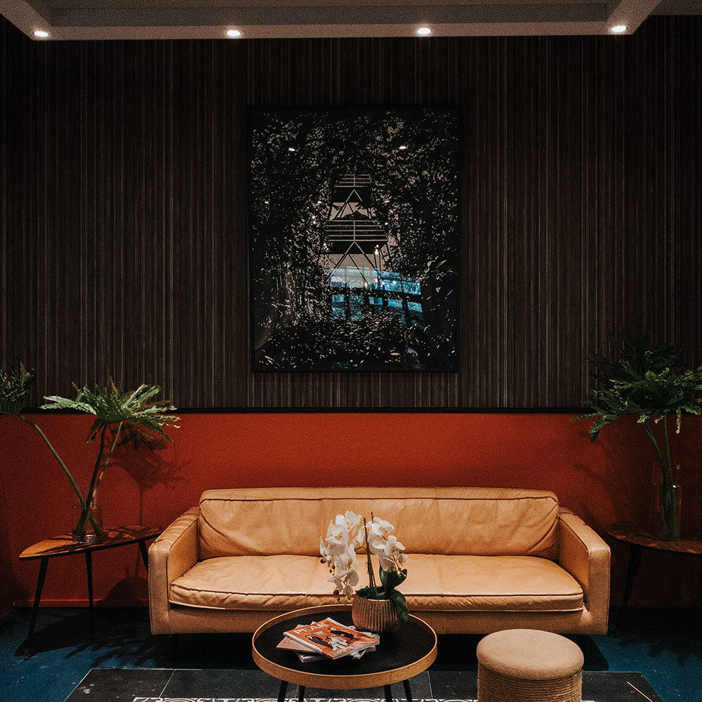 Faux Grasscloth Removable Wallpaper - A brown leather couch with two end tables and plants in a room featuring Faux Grasscloth Peel And Stick Wallpaper in textured black linen | Tempaper#color_textured-black-linen