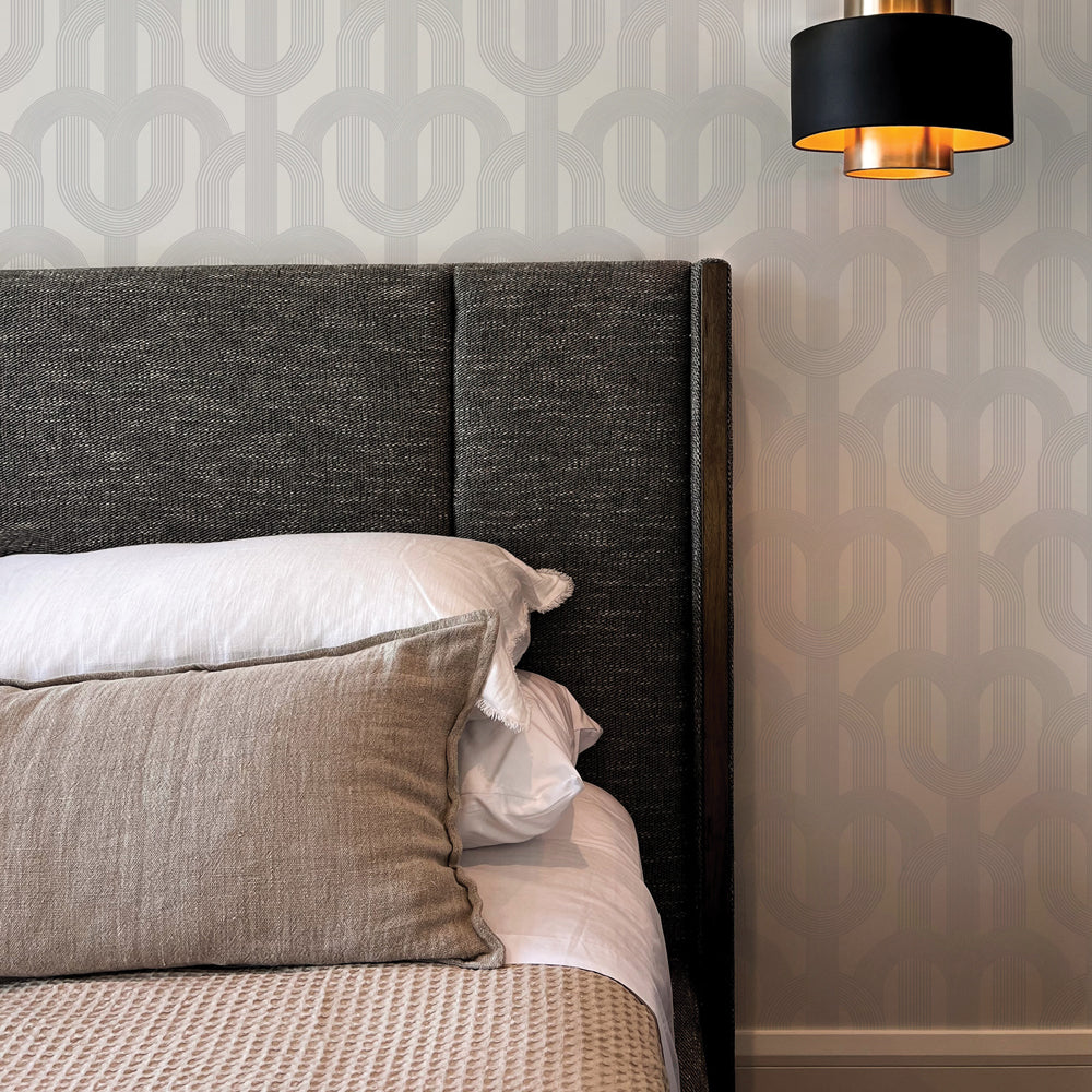 Light grey Lattice wallpaper print is on a wall behind a dark grey upholstered bed  #color_urban-grey