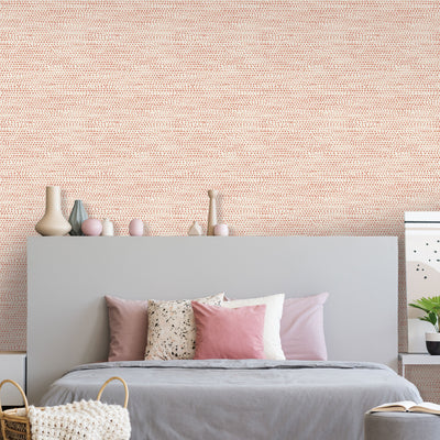 Moire Dots Removable Wallpaper - A bedroom with a grey bed in front of a wall featuring Tempaper's Moire Dots Peel And Stick Wallpaper in coral dots | Tempaper#color_coral-dots