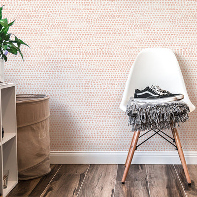 Moire Dots Removable Wallpaper - A white chair and white shelves in front of a wall featuring Tempaper's Moire Dots Peel And Stick Wallpaper in coral dots | Tempaper#color_coral-dots