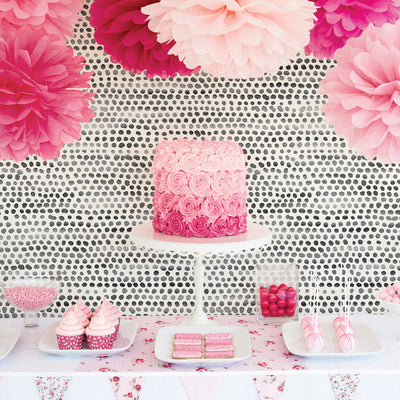 Moire Dots Removable Wallpaper - Pink flowers and pink deserts in front of a wall featuring Tempaper's Moire Dots Peel And Stick Wallpaper in black and white dots | Tempaper#color_black-and-white-dots