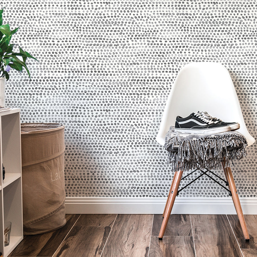 Moire Dots Removable Wallpaper - A white chair and white shelves in front of a wall featuring Tempaper's Moire Dots Peel And Stick Wallpaper in black and white dots | Tempaper#color_black-and-white-dots