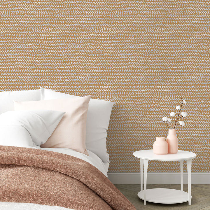 Moire Dots Removable Wallpaper - A bed and a white nightstand in a bedroom featuring Tempaper's Moire Dots Peel And Stick Wallpaper in toasted turmeric dots | Tempaper#color_toasted-turmeric-dots