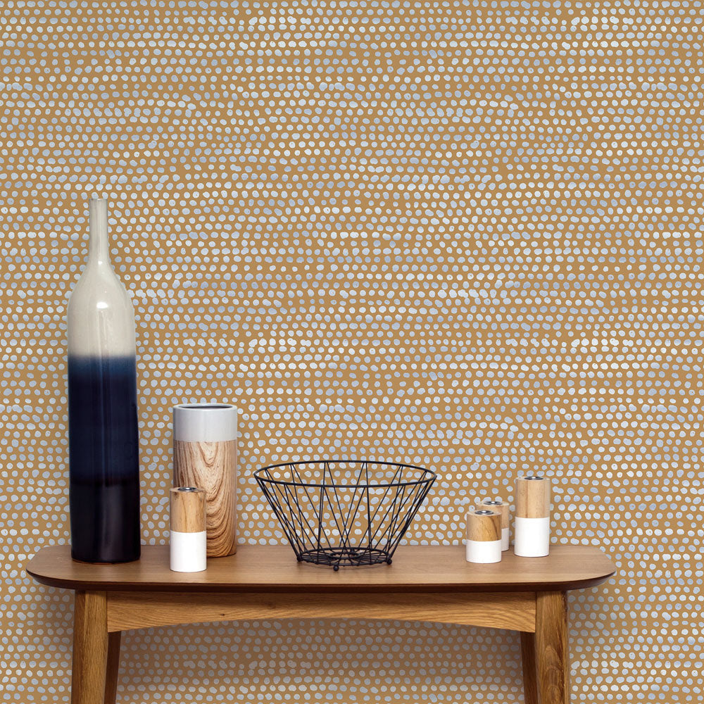 Moire Dots Removable Wallpaper - A wood bench with two vases and candles in front of a wall featuring Tempaper's Moire Dots Peel And Stick Wallpaper in toasted turmeric dots | Tempaper#color_toasted-turmeric-dots