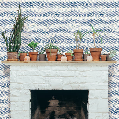 Moire Dots Removable Wallpaper - A fireplace with plants on top in a wall featuring Tempaper's Moire Dots Peel And Stick Wallpaper in blue moon dots | Tempaper#color_blue-moon-dots
