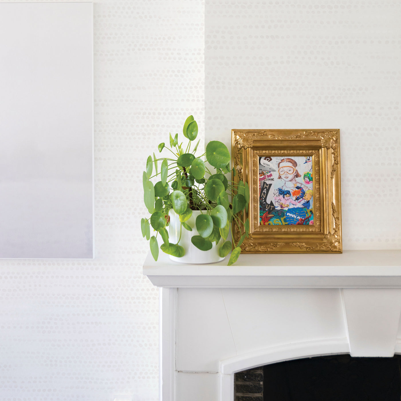Moire Dots Removable Wallpaper - A fireplace mantle with a plant and picture on top in a room featuring Tempaper's Moire Dots Peel And Stick Wallpaper in light tan dots | Tempaper#color_light-tan-dots