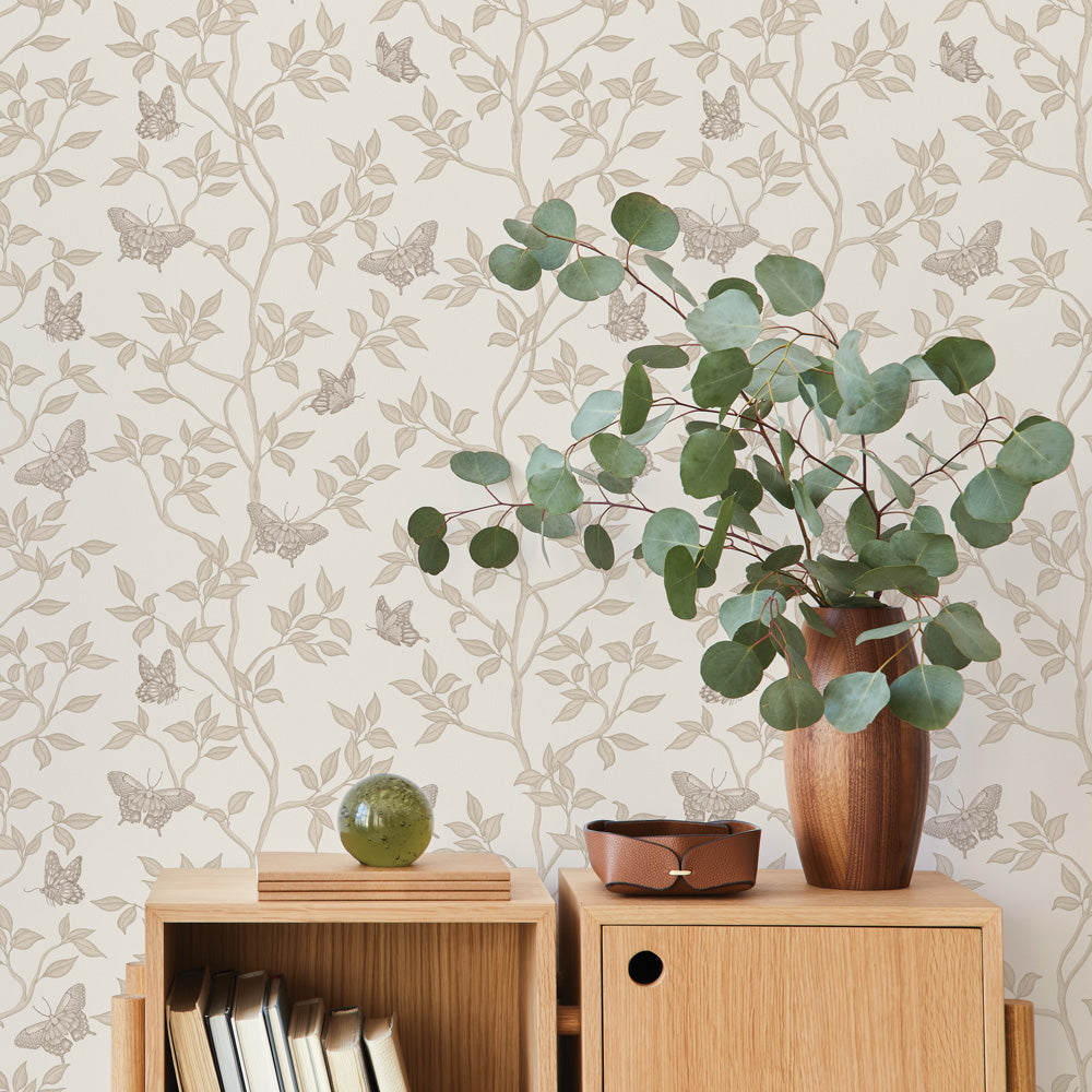 Monarch Non-Pasted Wallpaper - A wood dresser with a plant in a room featuring Monarch Unpasted Wallpaper in fawn | Tempaper#color_fawn