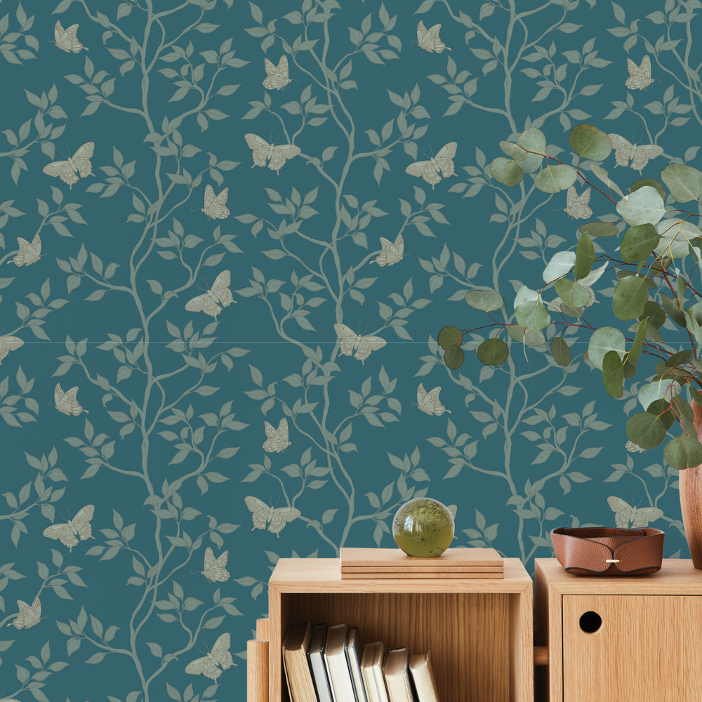 Monarch Non-Pasted Wallpaper - A wood dresser with a plant in a room featuring Monarch Unpasted Wallpaper in spruce | Tempaper#color_spruce