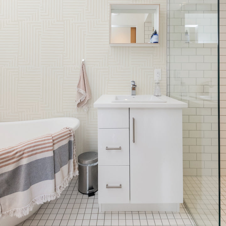 Tempaper's Geometric Patchwork Peel And Stick Wallpaper in a bathroom with a white vanity.