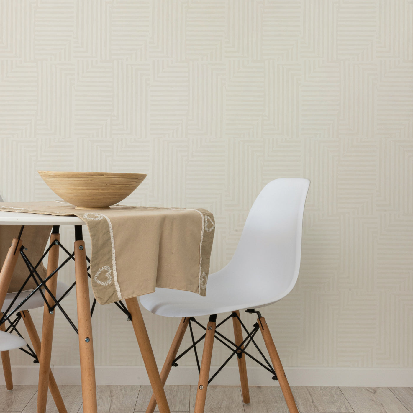 White chairs and a table with Tempaper's Geometric Patchwork Peel And Stick Wallpaper.