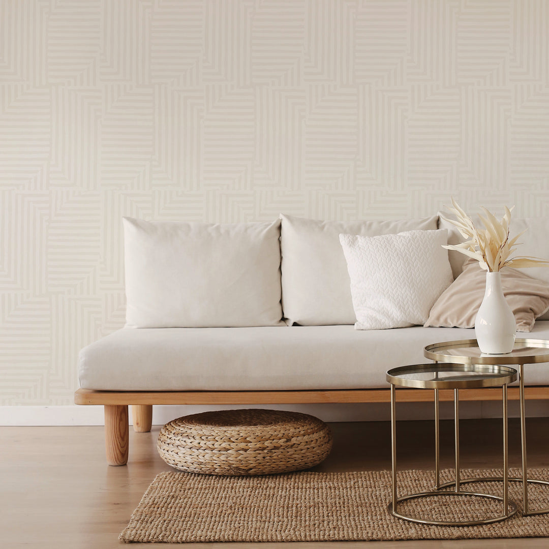 Tempaper's Geometric Patchwork Peel And Stick Wallpaper with a grey couch and bronze coffee table.