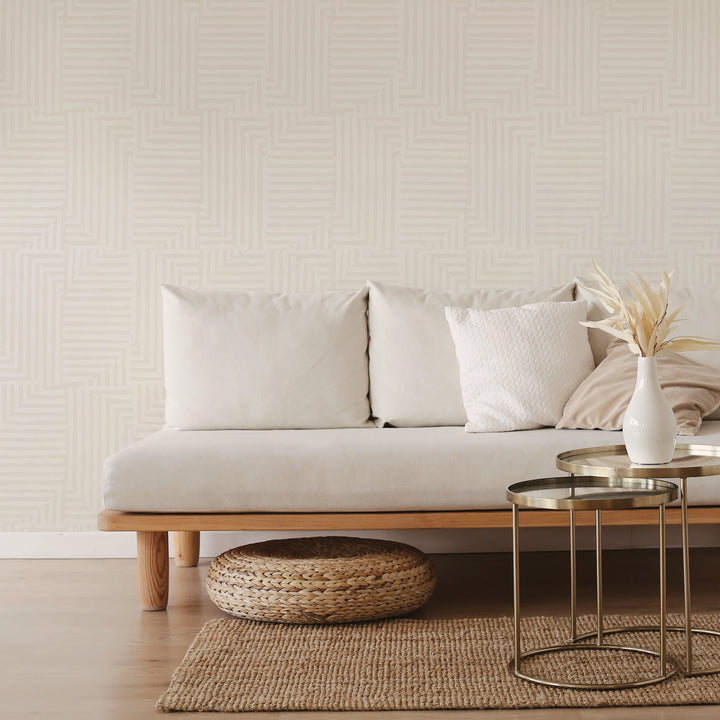 Tempaper's Geometric Patchwork Peel And Stick Wallpaper with a grey couch and bronze coffee table.