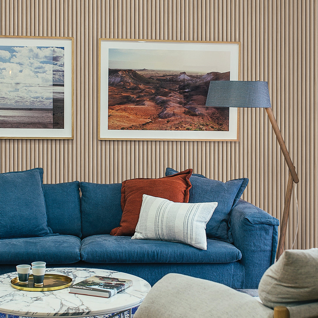 Reeded Wood peel and stick wallpaper in a living room displayed behind a couch.