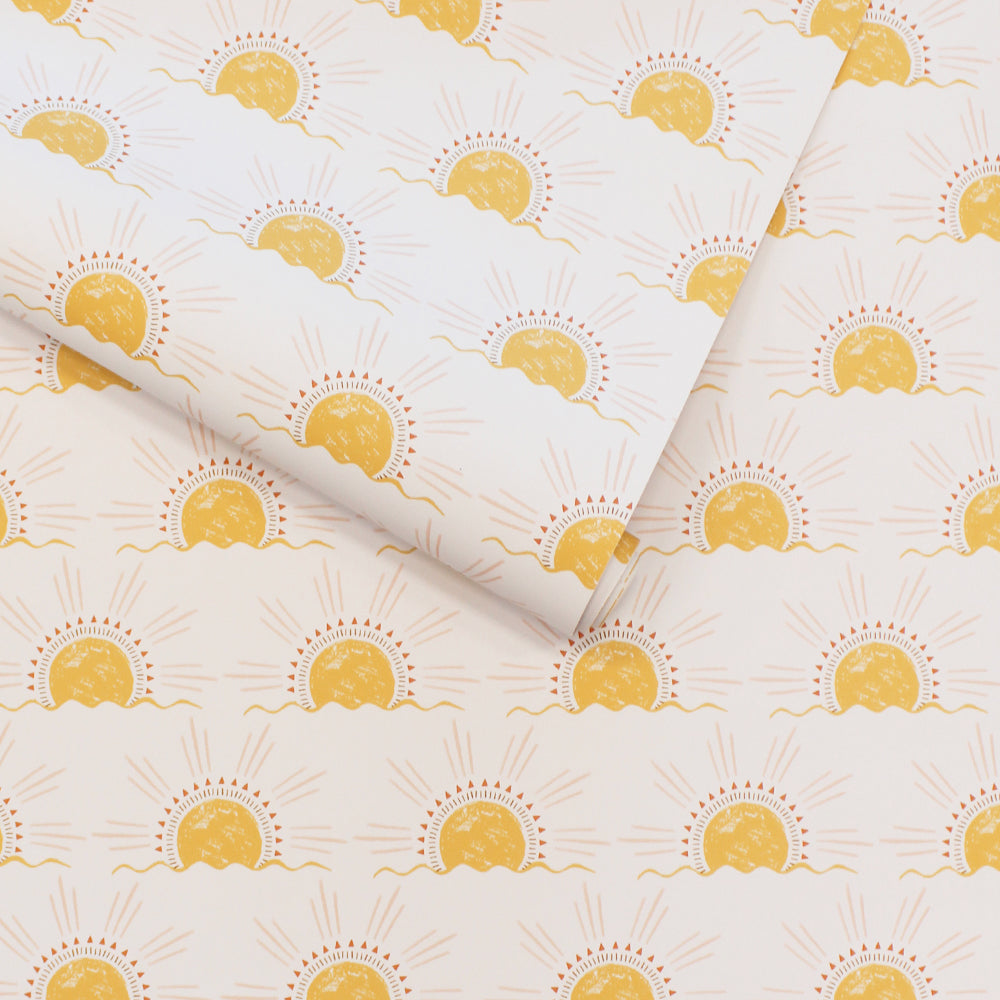 A slightly unraveled roll of Tempaper's Sun Peel And Stick Wallpaper.