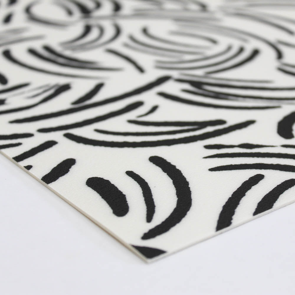 A corner view of the Abstract Lines Vinyl Rug in black and white.