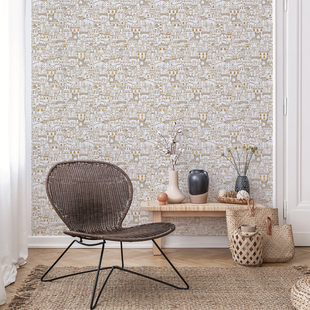 Amalfi WALLPAPER in metallic gold behind a table and chair.
