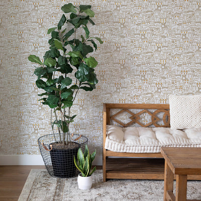 Amalfi WALLPAPER in metallic gold in a living room with a plant.