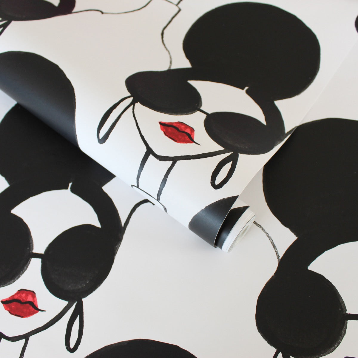A slightly unraveled roll of Tempaper's XOXO Stace Peel And Stick Wallpaper By Alice + Olivia.