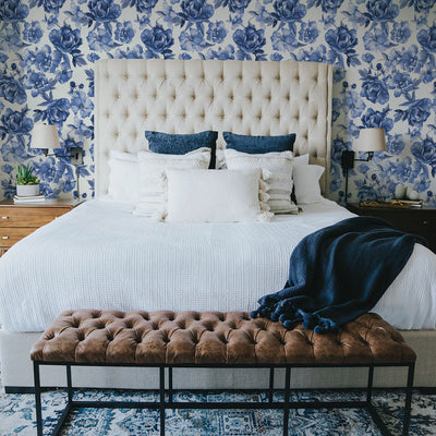 Tempaper's Forget-Me-Not Peel And Stick Wallpaper By Alice + Olivia shown in a bedroom behind a bed.