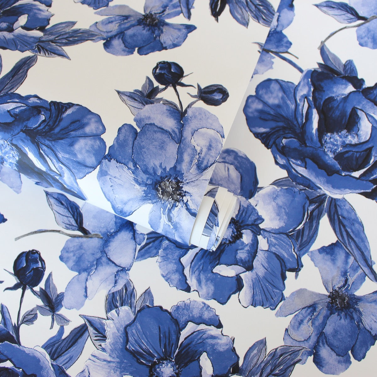 A slightly unraveled roll of Tempaper's Forget-Me-Not Peel And Stick Wallpaper By Alice + Olivia.