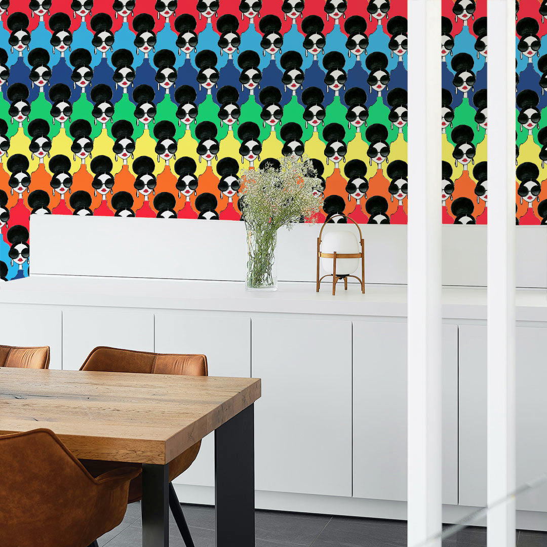 Tempaper's Rainbow Stace Peel And Stick Wallpaper By Alice + Olivia behind a wood table and several brown suede chairs.